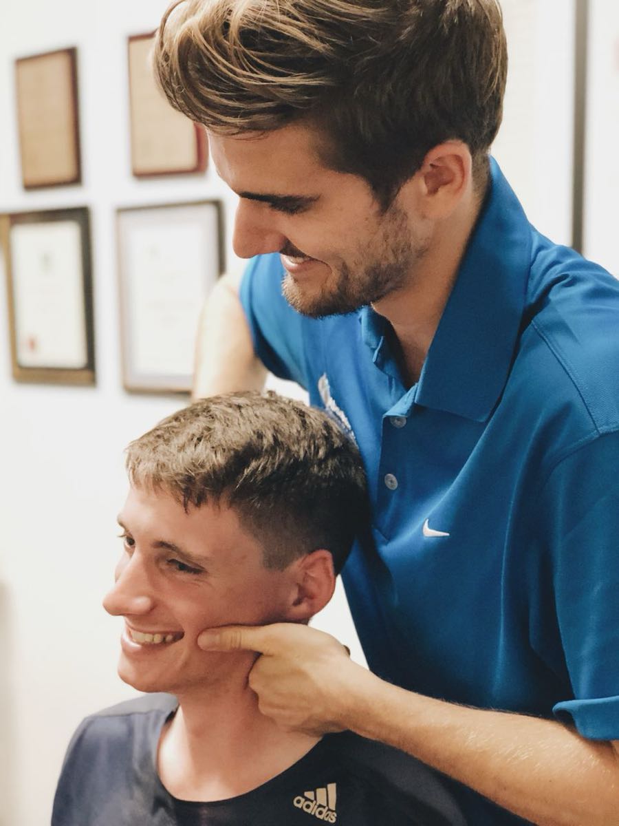 Chiropractor assessing patient's neck for headache relief on the Sunshine Coast.